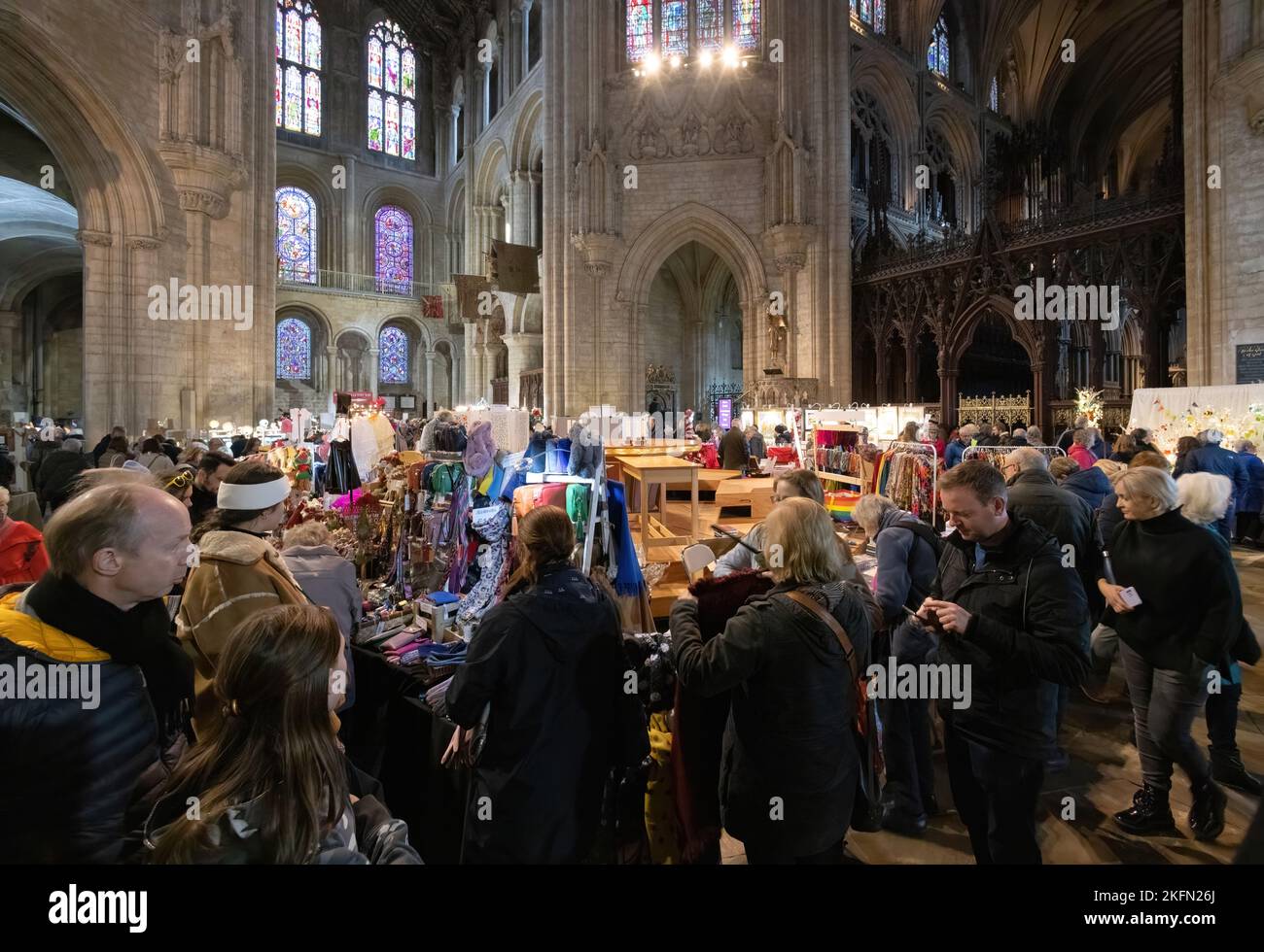 Fiera di Natale della Cattedrale di Ely - la gente che acquista al cibo e bancarelle del mercato dei regali a Natale, all'interno della cattedrale, Ely Cambridgeshire UK Foto Stock