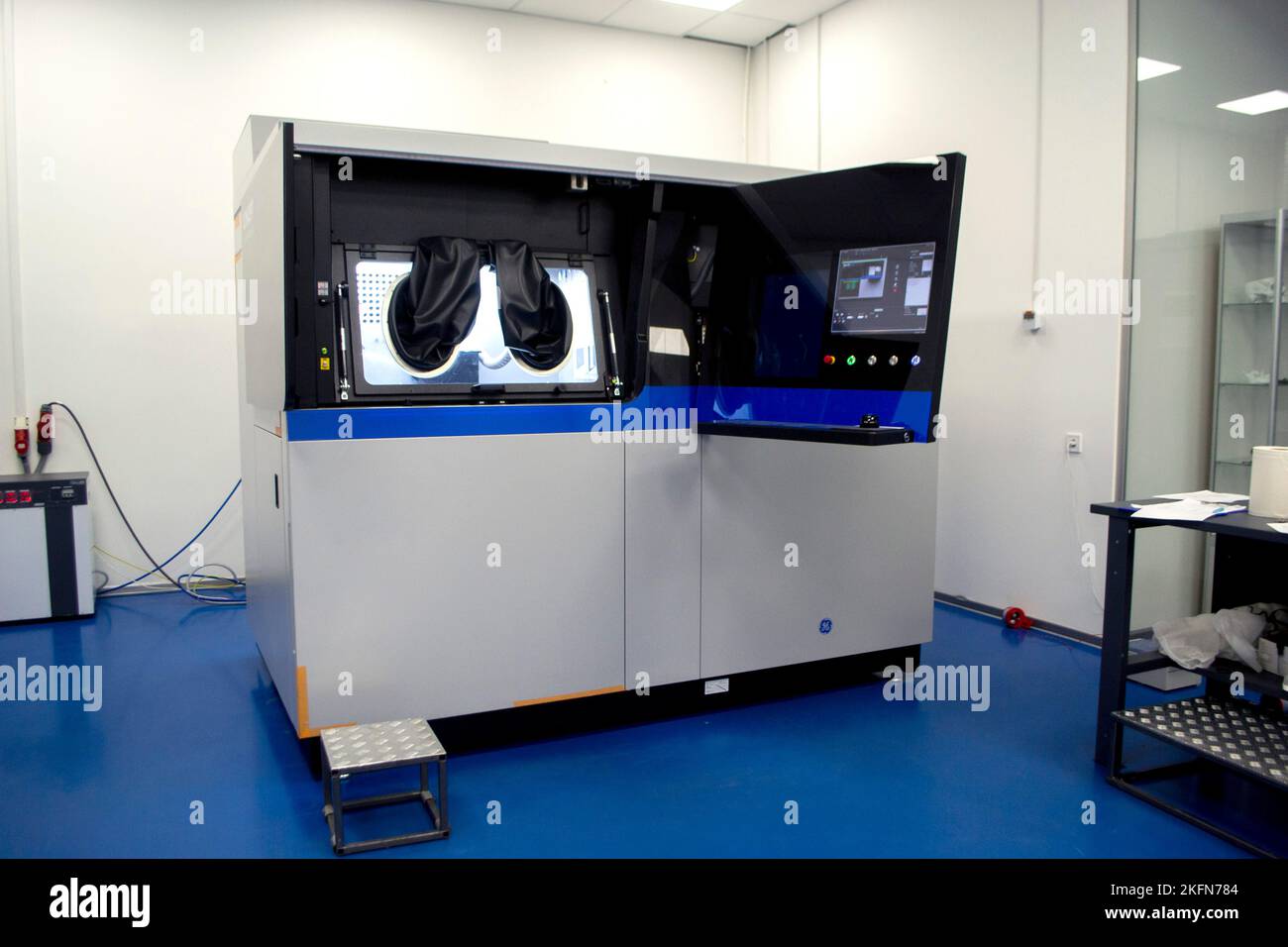 Stampante industriale 3D per polveri metalliche con le mani che indossano guanti in gomma nera grandi per la sigillatura e il pannello di controllo. Macchina sinterizzatrice laser per metallo. Stampante 3D per la stampa da polvere metallica Foto Stock