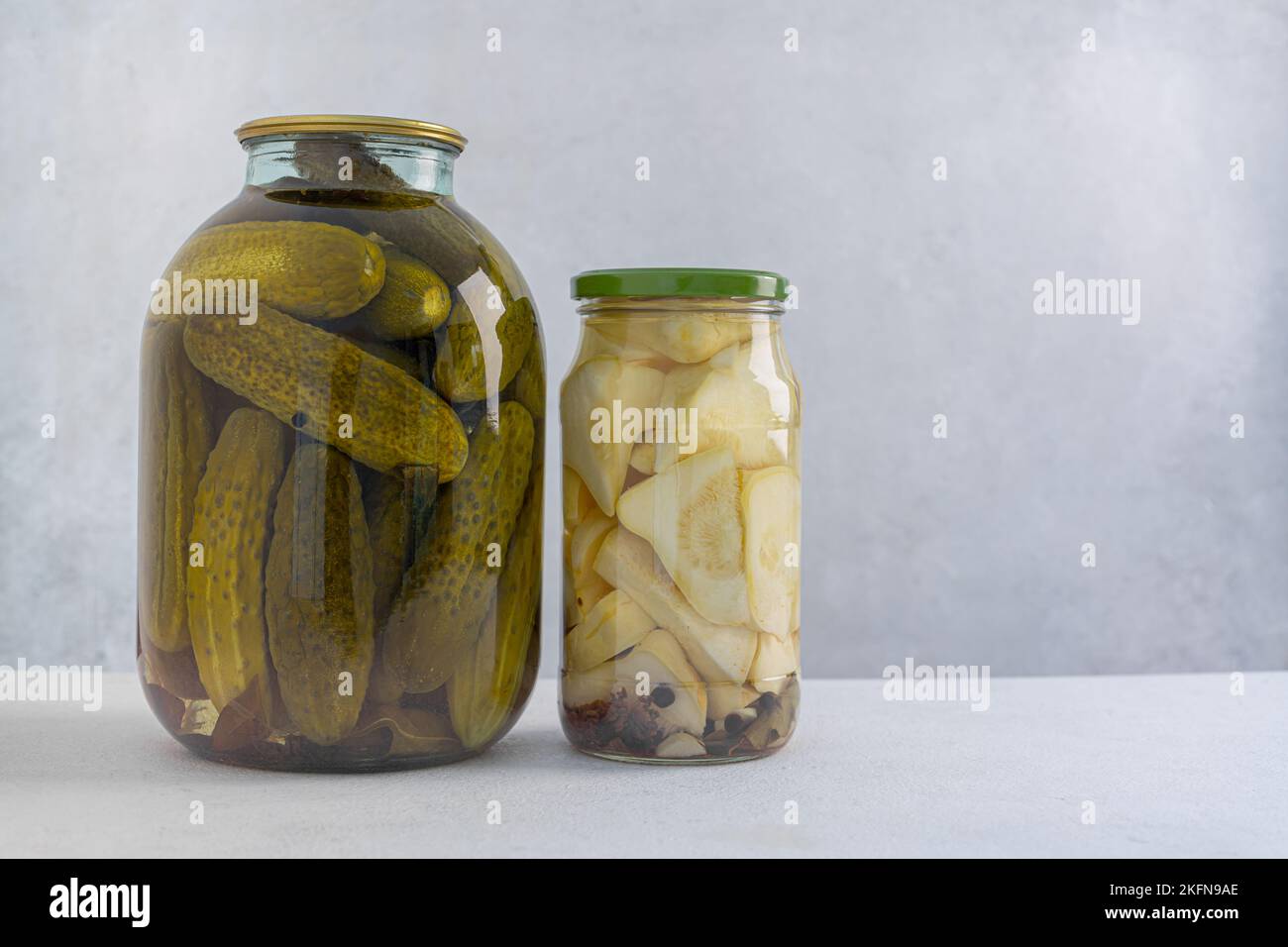 Cetrioli sott'aceto in un vaso di vetro su sfondo chiaro. Cetrioli fermentati o decapati fatti in casa. Foto Stock