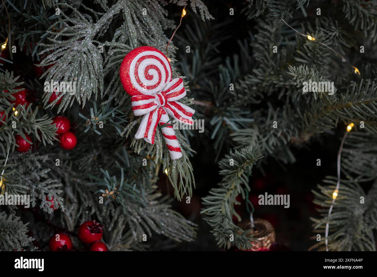 Ornamenti di Natale caramelle e decorazione di luce fata su un albero di natale al tempo dell'Avvento Foto Stock