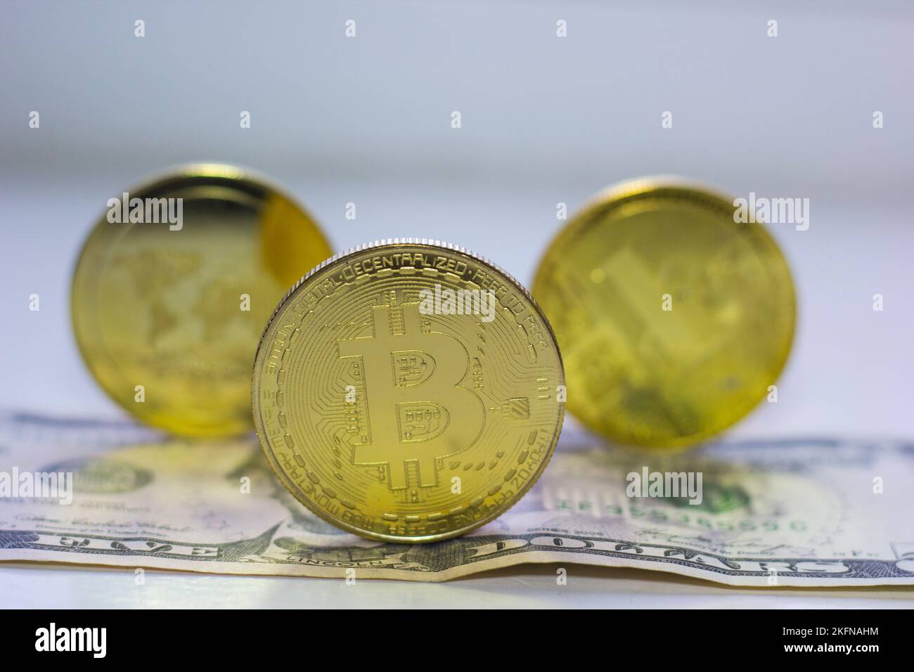 Tre monete da criptovaluta in un primo piano di un disegno di legge in dollari Foto Stock