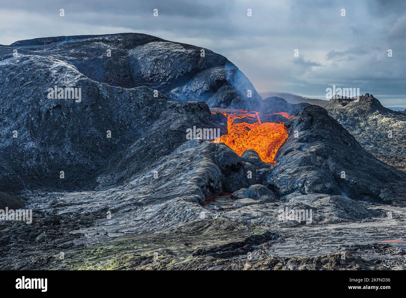 Paesaggio in Islanda sulla penisola di Reykjanes. basso flusso di lava da un cratere vulcanico attivo. Cratere con roccia magma raffreddata e liquida. magma scuro Foto Stock