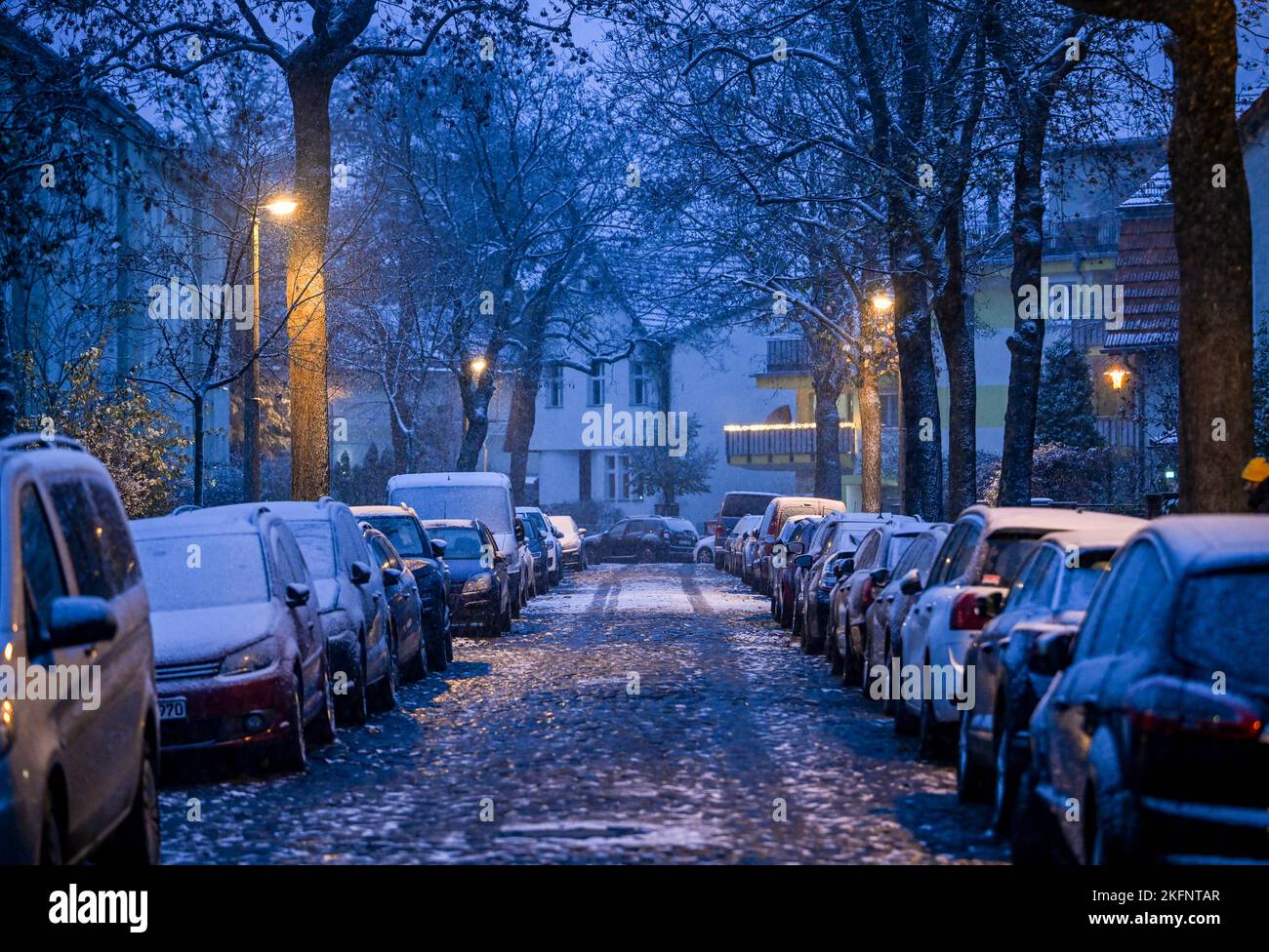 Berlino, Germania. 19th Nov 2022. Coperto di neve nel pomeriggio è una strada acciottolata e le auto parcheggiate lì a Karlshorst. Credit: Jens Kalaene/dpa/Alamy Live News Foto Stock