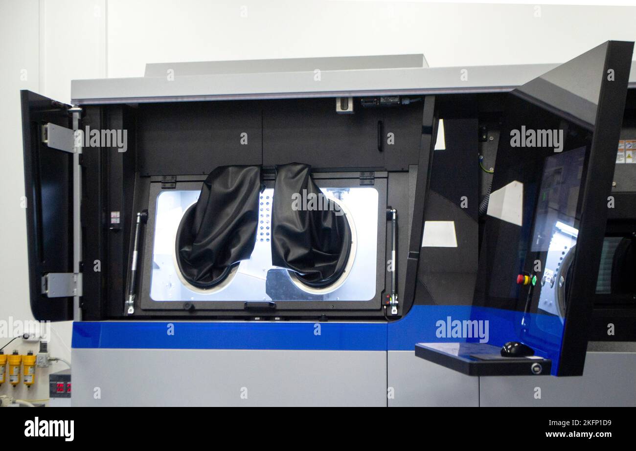 Stampante industriale 3D per polveri metalliche con le mani che indossano guanti in gomma nera grandi per la sigillatura e il pannello di controllo. Macchina sinterizzatrice laser per metallo. Stampante 3D per la stampa da polvere metallica Foto Stock