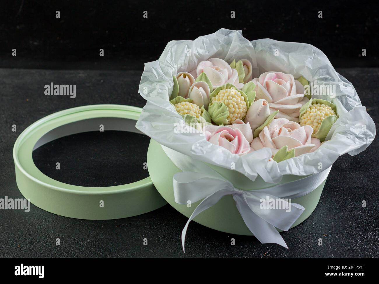 Un bouquet di fiori di zephyr - marshmallows in una bella scatola su uno sfondo scuro Foto Stock