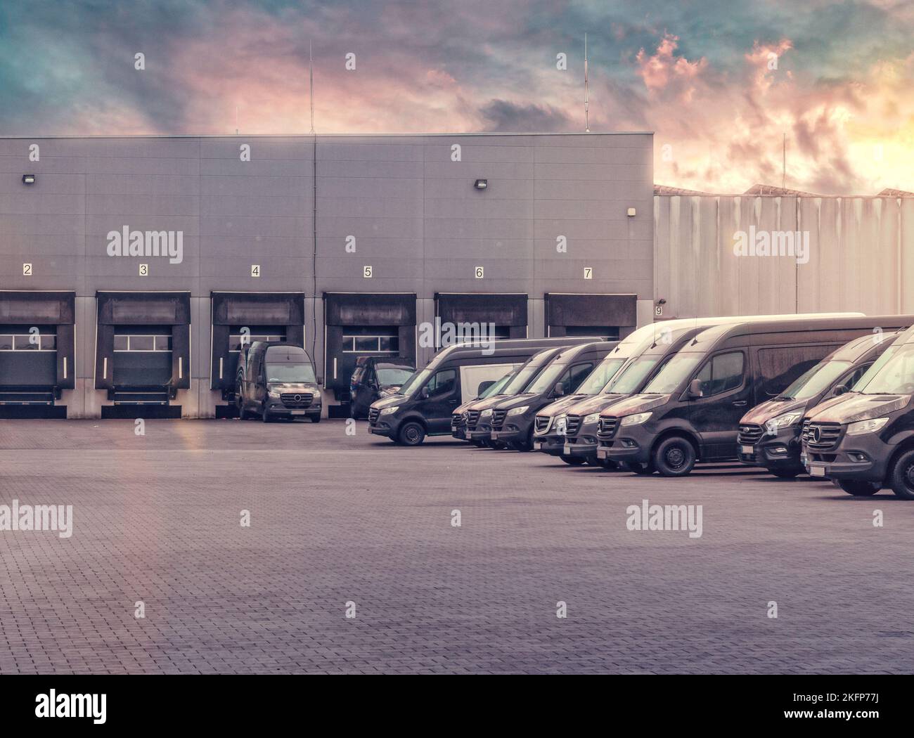 Parcheggio veicoli all'interno dell'azienda. Stazioni di ricarica e tramonto. In attesa di nuovi ordini. Carico merci di trasporto Foto Stock