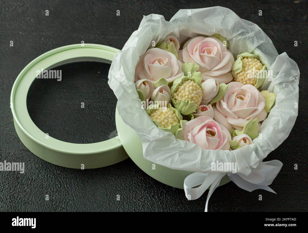 Un bouquet di fiori di zephyr - marshmallows in una bella scatola su uno sfondo scuro Foto Stock