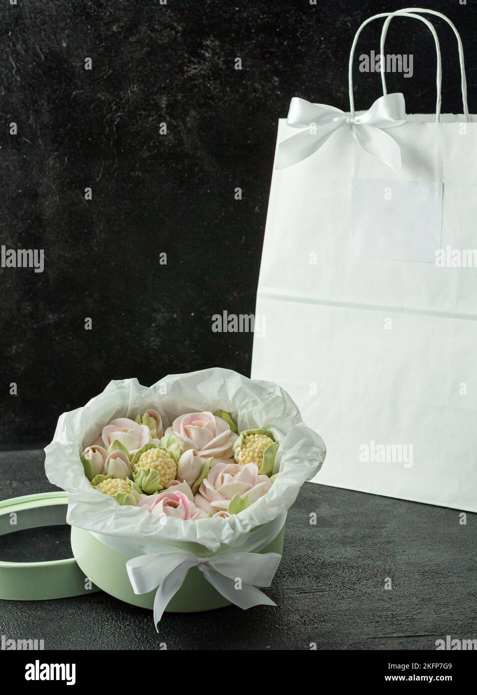 Un bouquet di fiori di zephyr - marshmallows in una bella scatola su uno sfondo scuro Foto Stock