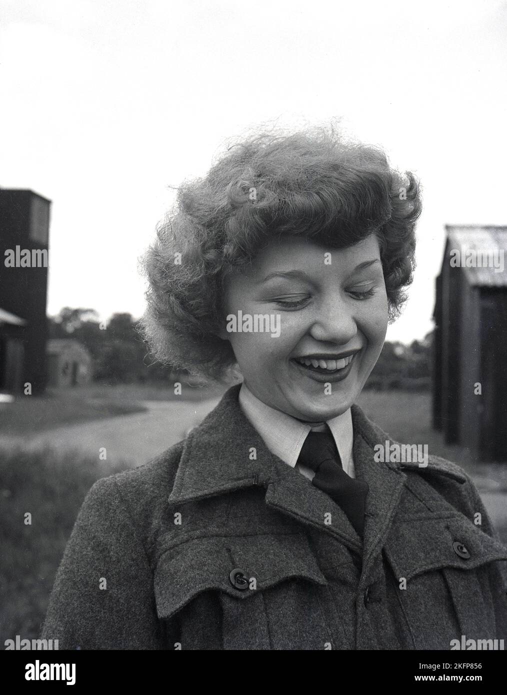 1940s, storico, in piedi fuori del campo, a RAF Ternhill, Longford Camp, vicino a Market Drayton, Shropshire, Inghilterra, Regno Unito, una giovane donna WAAF in colletto e cravatta e tunica di stoffa di lana. La Women's Auxillary Air Force (WAAF) è stata formata nel giugno 1939, con reclute intitali di età compresa tra i 18-43 anni. Foto Stock