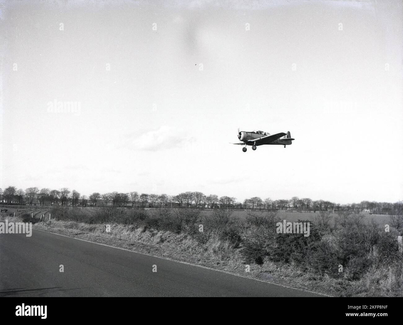 1949, storico, un velivolo a motore singolo nel cielo, un allenatore di Harvard nordamericano che arriva a terra a RAF Ternhill, Market Drayton, Shropshire, Inghilterra, Regno Unito. L'aerodome di Tern Hill aprì per la prima volta nel 1916, ma poi chiuse nel 1922. Con i timori di un saccheggiante conflitto di guerra, la terra è stata nuovamente richiesta nel 1935, mentre il programma di espansione RAF è iniziato. Foto Stock