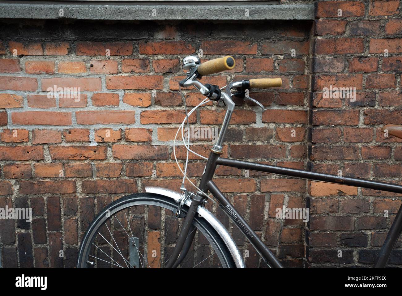Pedalò d'epoca parcheggiato su una strada a Copenhagen, Danimarca. Bici parcheggiata di fronte a un muro di mattoni. Città più verde d'Europa, trasporto sostenibile. Foto Stock