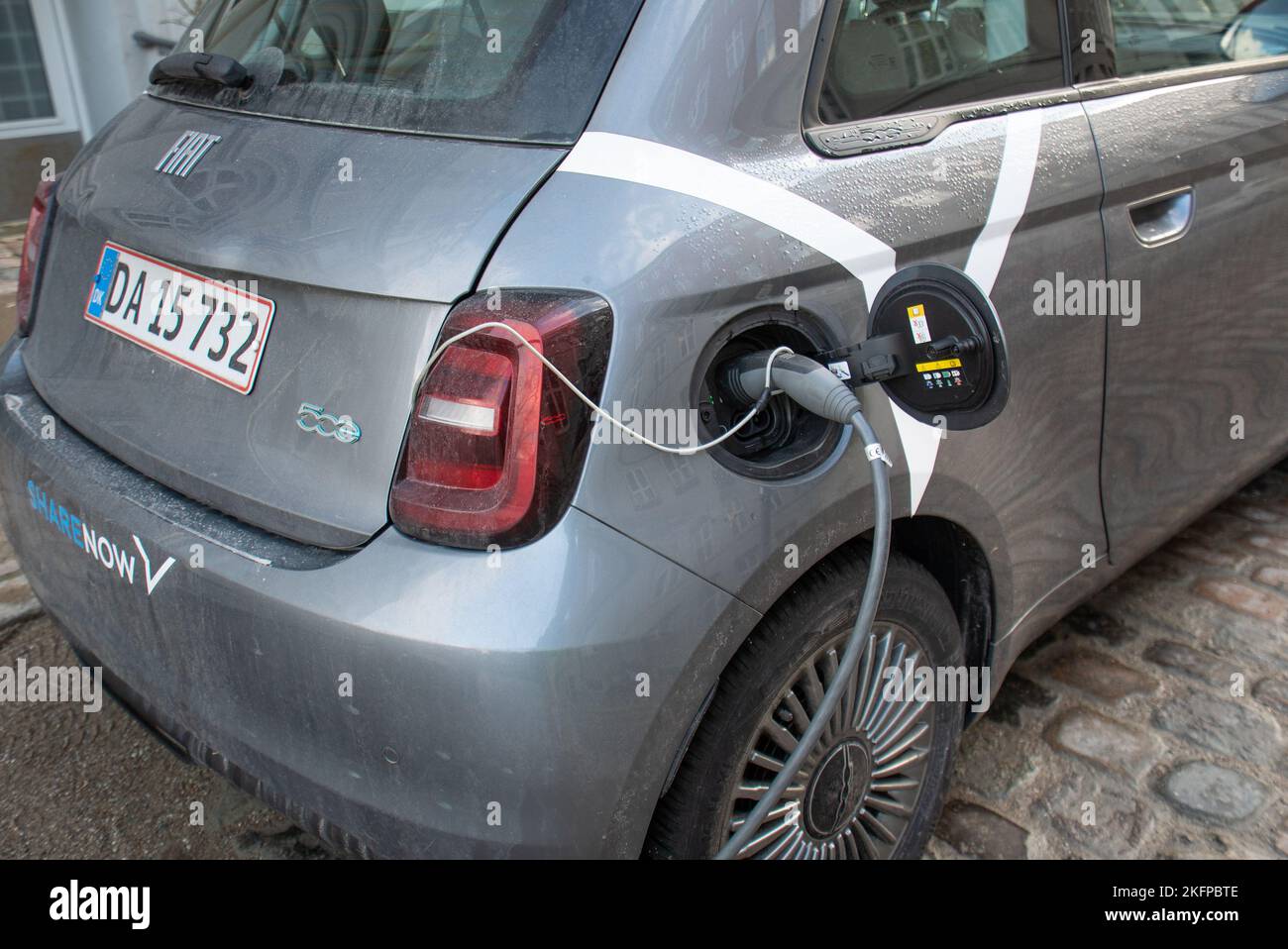 Ricarica di auto elettriche: Un'auto Fiat 500 che ricarica la batteria in un punto di ricarica a Copenaghen, Danimarca, Europa. Trasporto sostenibile. Foto Stock