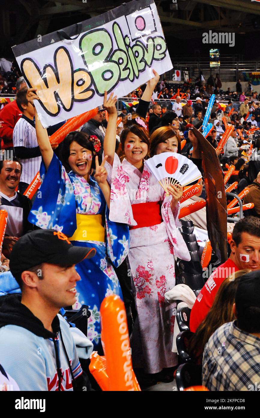 Giovani tifosi, vestite con tradizionali kimono giapponesi e con una bandiera, allietano la nazionale giapponese al World Baseball Classic Foto Stock