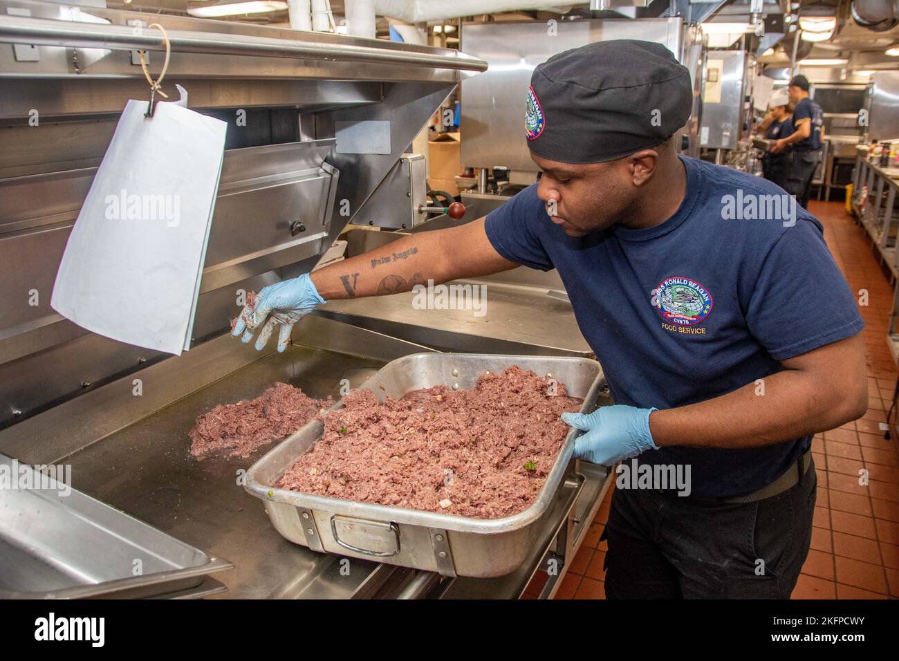 220930-N-BR419-1006 WATERS EAST OF THE KOREAN PENINSULA (SETT. 30, 2022) Specialista culinario Seaman Gisaiah Willard, di Oakland, California, cuoce carne macinata su una griglia nella cucina in avanti durante un cuoco a bordo dell'unica portaerei della Marina statunitense, USS Ronald Reagan (CVN 76), nelle acque ad est della penisola coreana, settembre 30. Ronald Reagan, il fiore all'occhiello del Carrier Strike Group 5, fornisce una forza pronta per il combattimento che protegge e difende gli Stati Uniti, e sostiene alleanze, partnership e interessi marittimi collettivi nella regione del Pacifico. Foto Stock