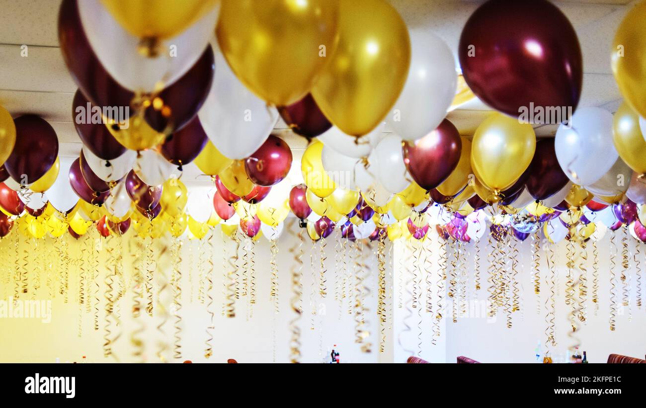 Palloncini colorati appendono sotto il soffitto bianco nel cafe' Foto Stock