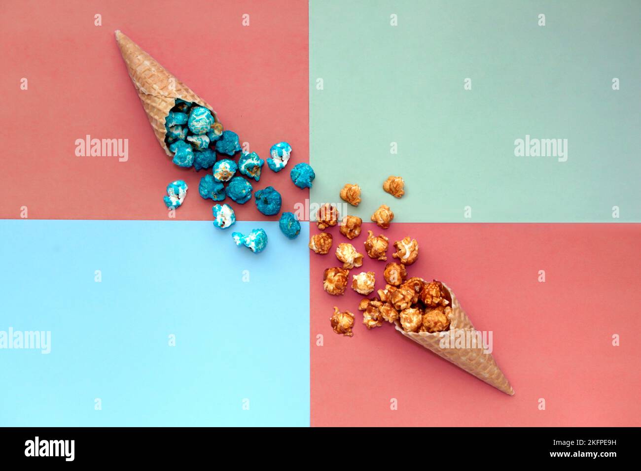 Cono gelato waffle con sfondo colorato Popcorn spill-terracota. fast food snack cornucopia Foto Stock