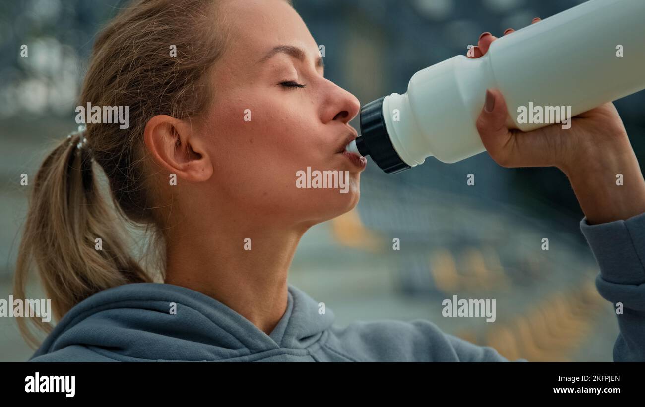 Donna sana atletica sportswoman caucasica ragazza runner jogger atleta femmina bere acqua fresca acqua fredda nutrimento sportivo proteine per l'energia Foto Stock