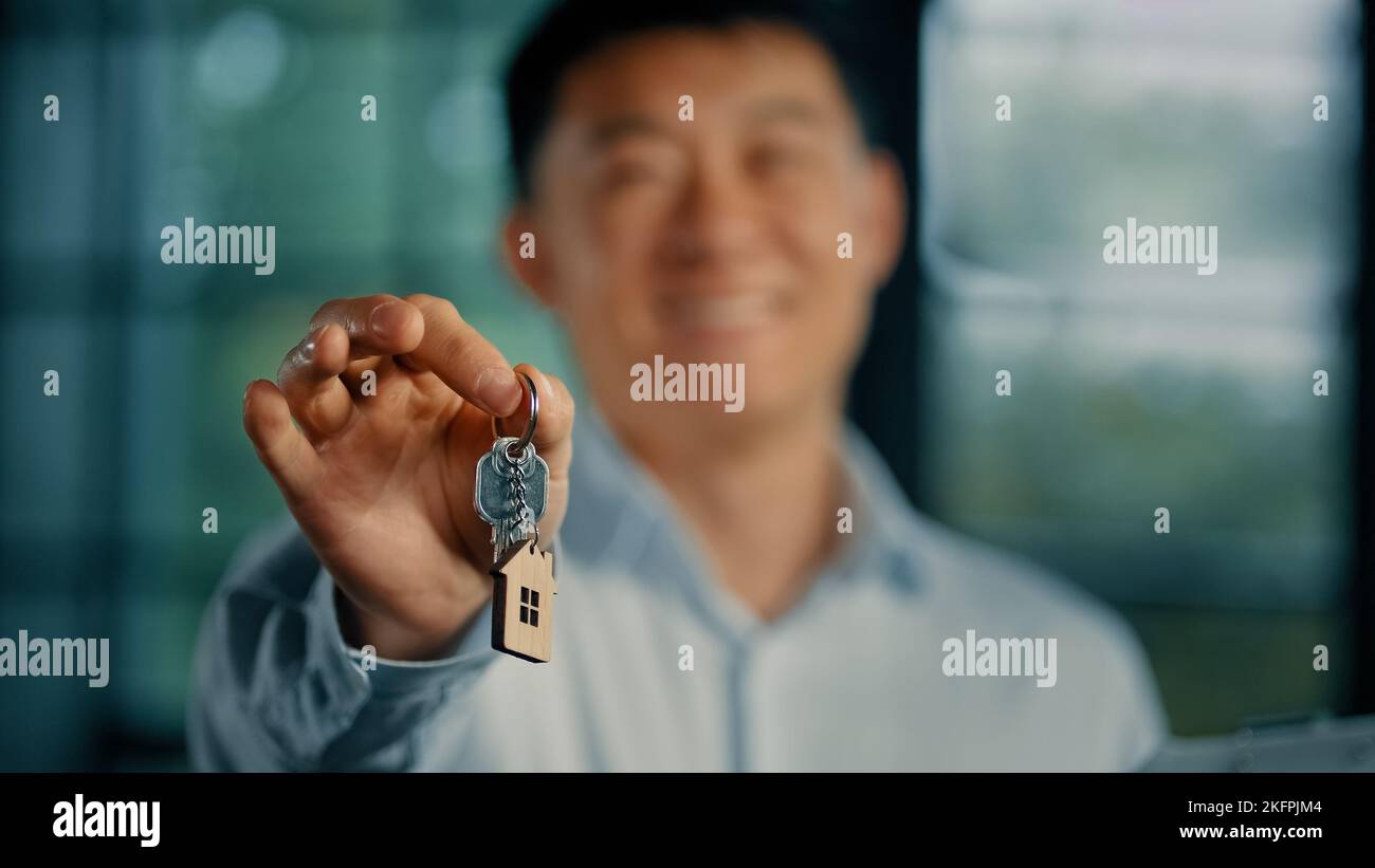Felice uomo asiatico di successo proprietario di casa imprenditore realtor estate manager tenere le chiavi di moderno ufficio acquistare nuovo appartamento investire in realty housing ipoteca Foto Stock