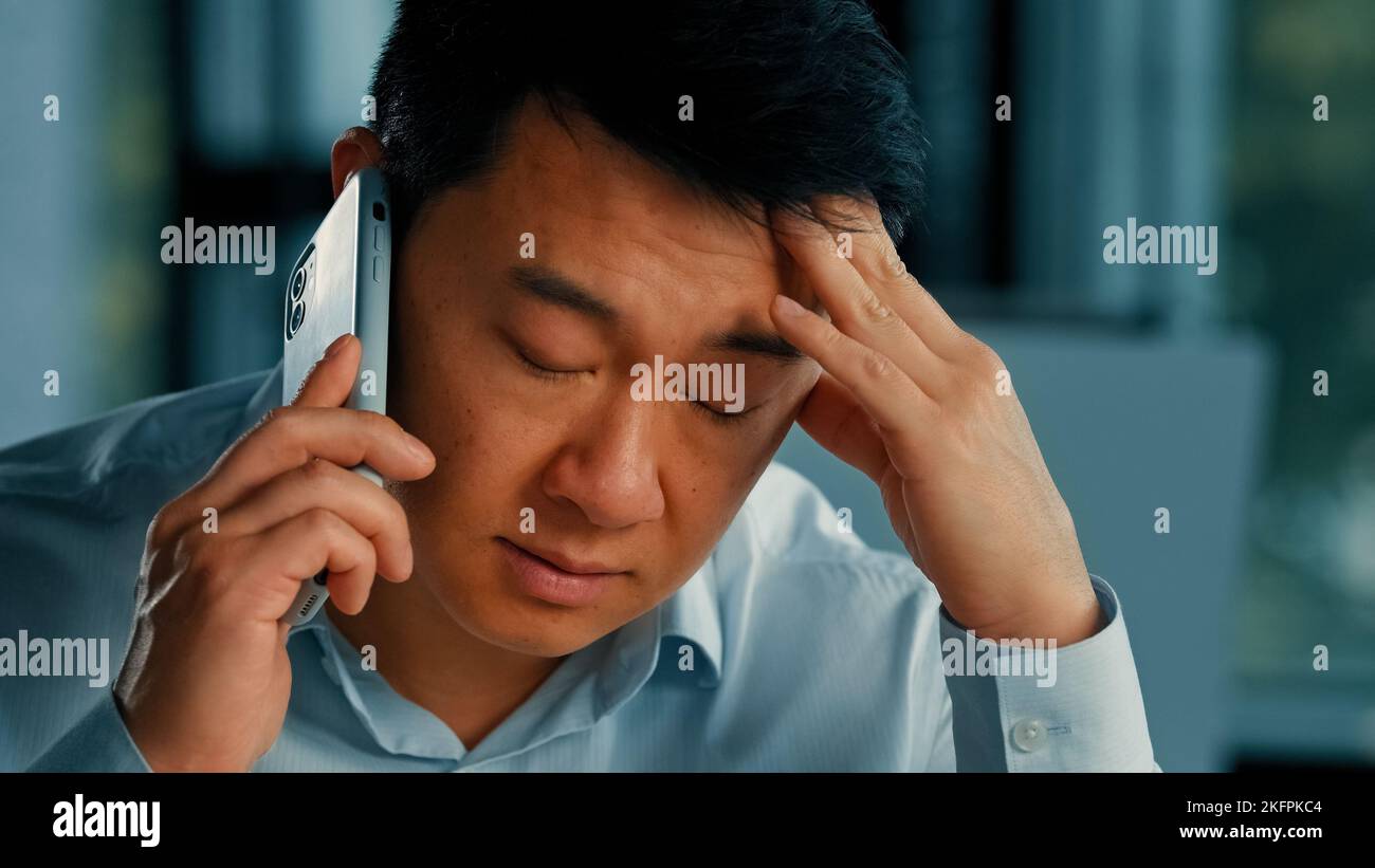 Insoddisfatto cliente uomo d'affari maschio infastidito asiatico coreano arrabbiato uomo parlare telefono cellulare ha fraintendimento problemi lamentele con il cliente risolvere Foto Stock
