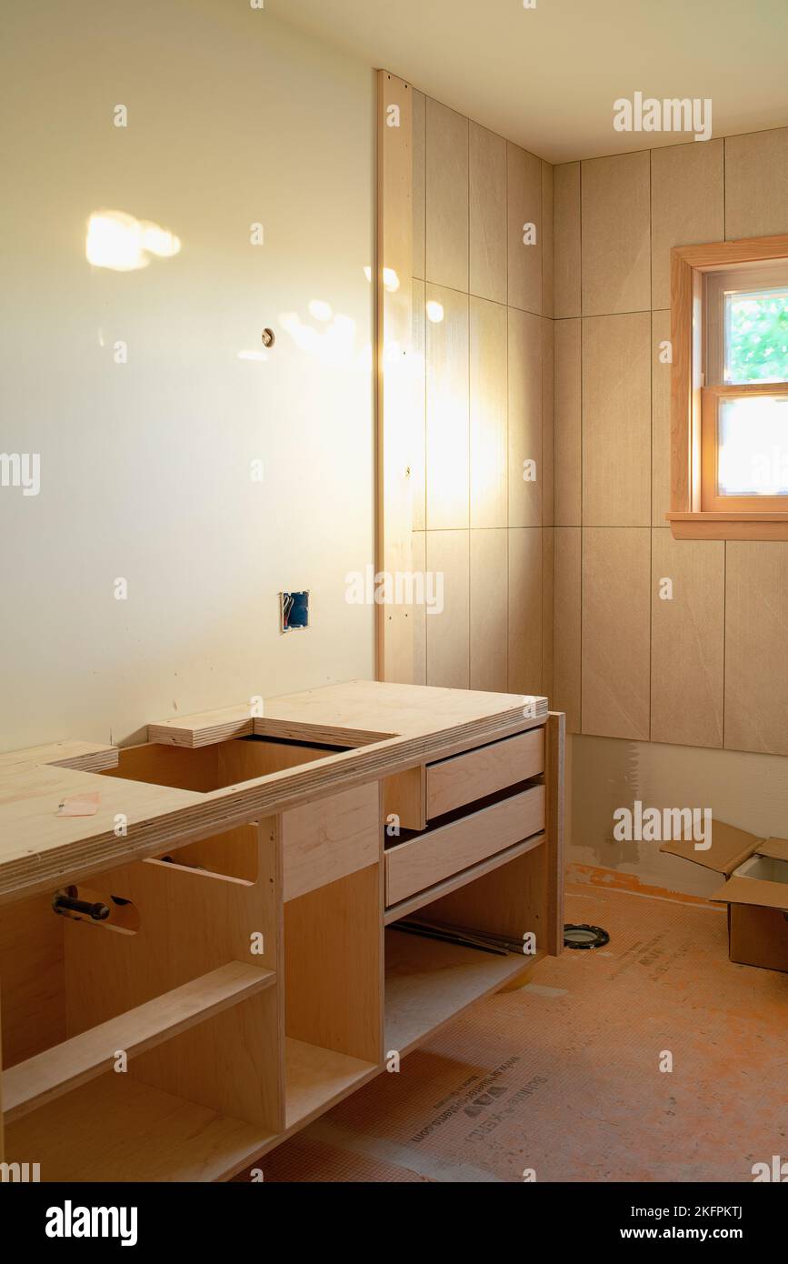 Un bagno ristrutturato con nuove piastrelle e armadi personalizzati. Foto Stock
