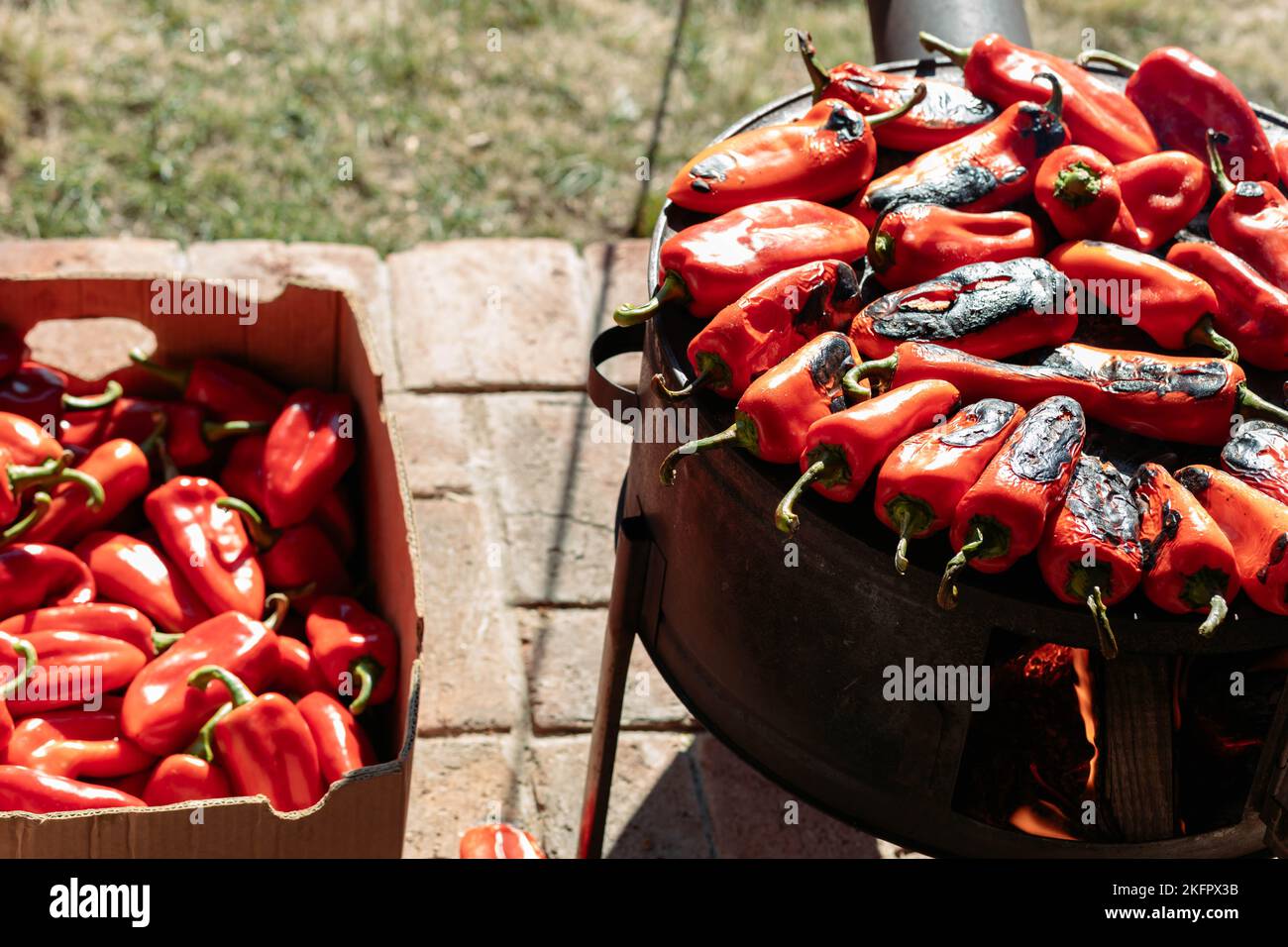 Arrostire peperoni rossi, paprika, per la preparazione di ajvar. Cibo tradizionale balcanico Foto Stock