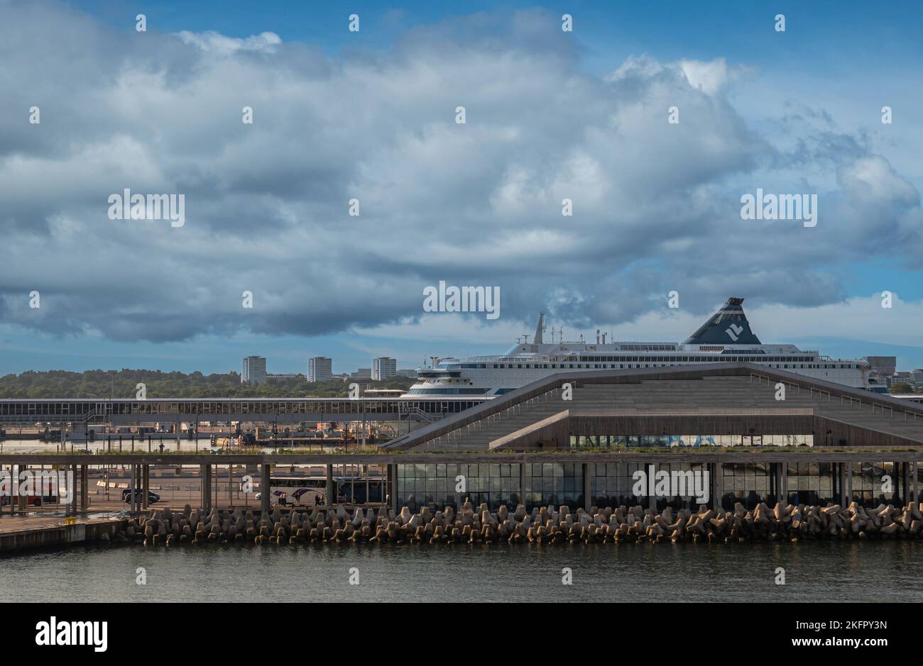 Estonia, Tallinn - 21 luglio 2022: Il traghetto Isabelle sbirra sopra il terminal delle navi da crociera grigio di vetro, legno e cemento sotto il paesaggio blu del mattino. Onda sto Foto Stock