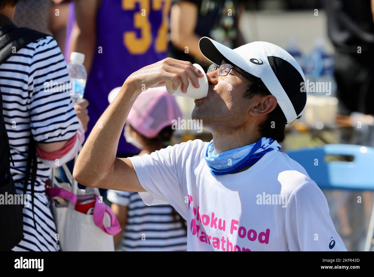 Un corridore locale si riidrata dopo la gara di mezza maratona di 13,1 miglia del 2 ottobre su Sagami General Depot, Giappone. Circa 7.000 persone hanno partecipato agli eventi di quel giorno, che comprendevano una corsa di staffetta aggiuntiva e un festival a post aperto. Foto Stock