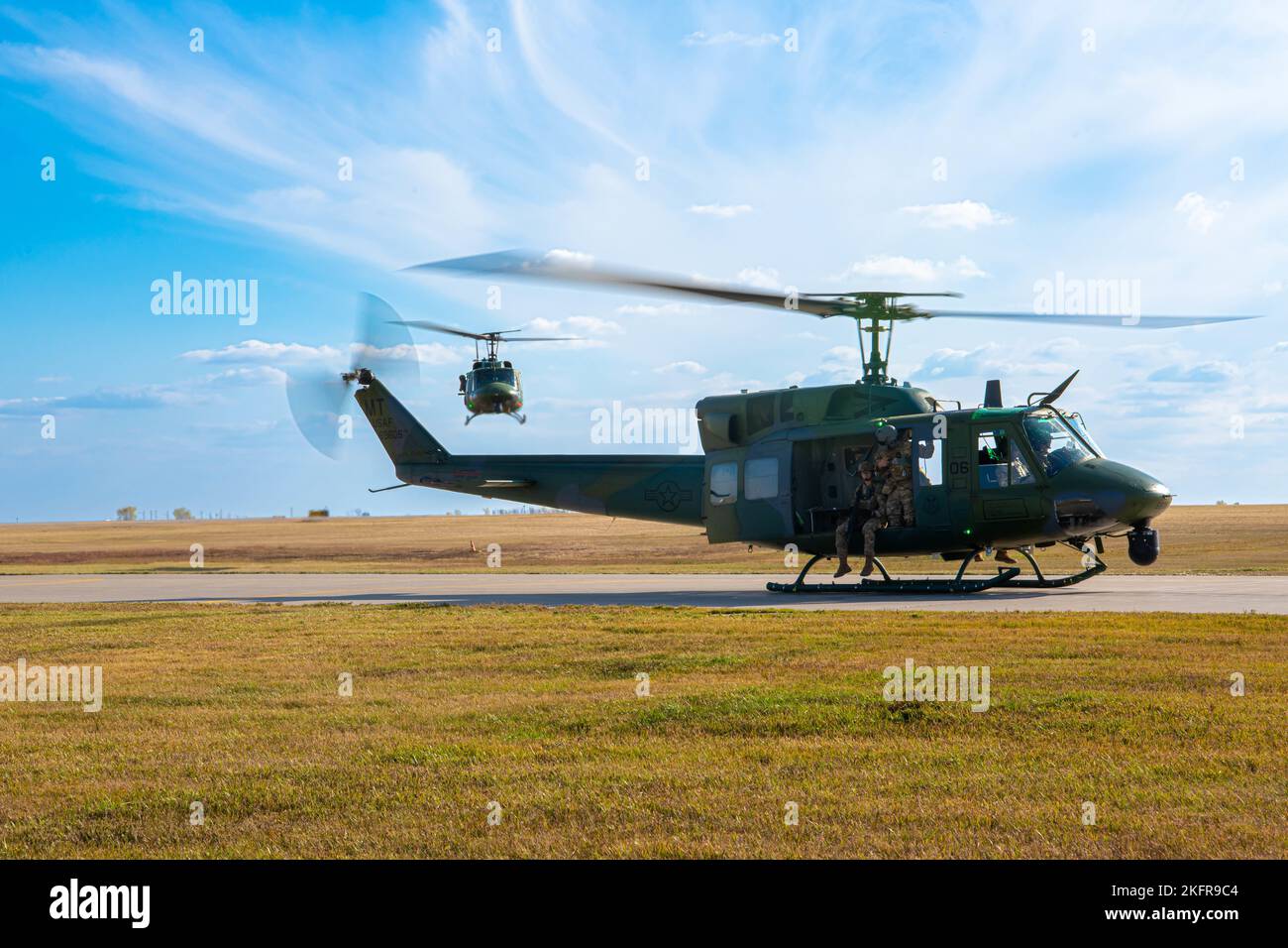 Due UH-1 Hueys del 54th Helicopter Squadron atterrano all'hangar dell'elicottero alla base dell'aeronautica di Minot, North Dakota, 3 ottobre 2022. Lo Squadrone elicottero 54th collabora con l'ala missilistica 91st per garantire la sicurezza dei siti missilistici. (Airman 1st Class Alexander Nottingham) Foto Stock