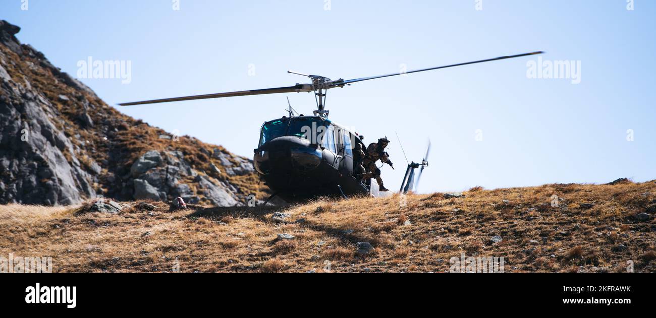 Un soldato dell'Esercito italiano con la Brigata Alpini salta da un elicottero UH-60 Blackhawk per attaccare un obiettivo durante un esercizio di fuoco in bianco accanto ai paracadutisti dell'Esercito USA assegnati a 2nd battaglione, 503rd reggimento di fanteria paracadute come parte dell'esercizio Summer Resolve nella Provincia di Bolzano, Italia, 3 ottobre 2022. Exercise Alpine Star è un esercizio annuale di addestramento in montagna e artico organizzato dall'Esercito Italiano, multinazionale e multifase. I paracadutisti della ricognizione della Brigata Airborne 173rd si integrano all’interno di alcune aziende selezionate della Brigata Alpini dell’Esercito Italiano per imparare il techn Foto Stock
