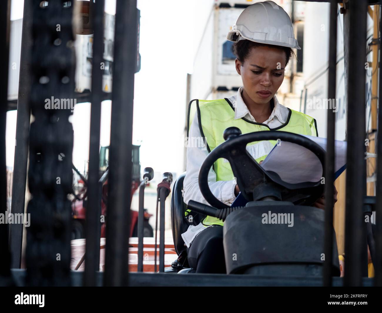 Ingegnere caposquadra personale dipendente bianco casco di elmetto sit carrello elevatore conducente donna donna donna pelle nera persona africana importazione esportazione log di spedizione Foto Stock