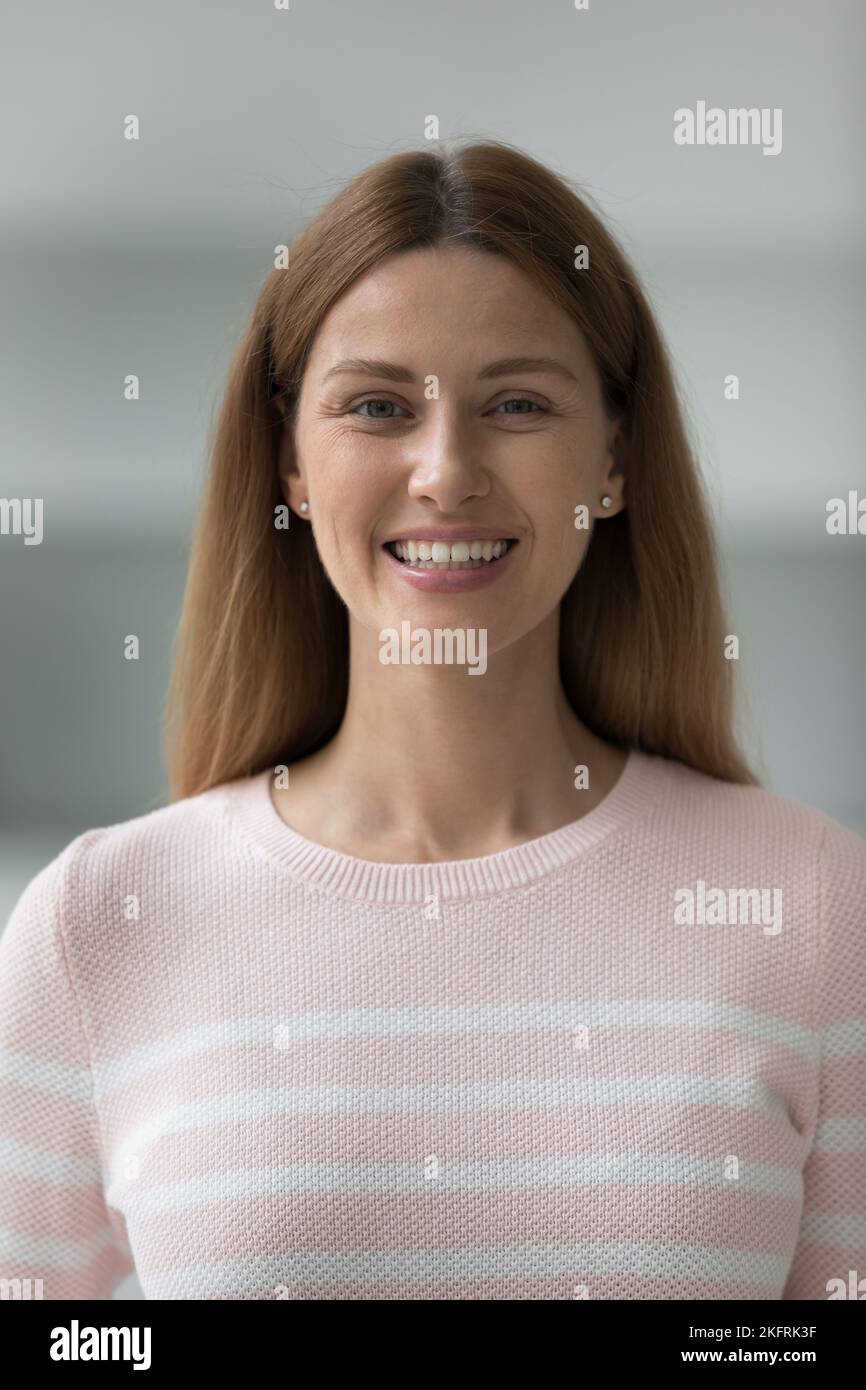 Scatto verticale bellissimo sorriso giovane donna fissando la fotocamera Foto Stock