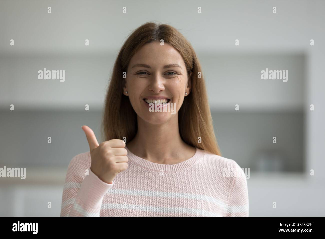 Ritratto di donna che mostra pollici verso l'alto guardare la fotocamera Foto Stock