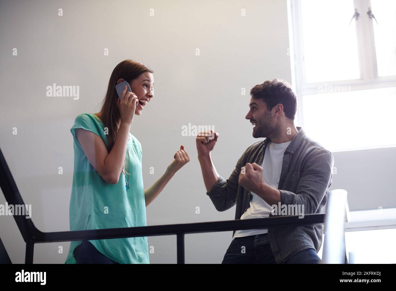 In attesa delle notizie impressionanti. Una donna ecstatic sul suo telefono ed un amico eccitato. Foto Stock