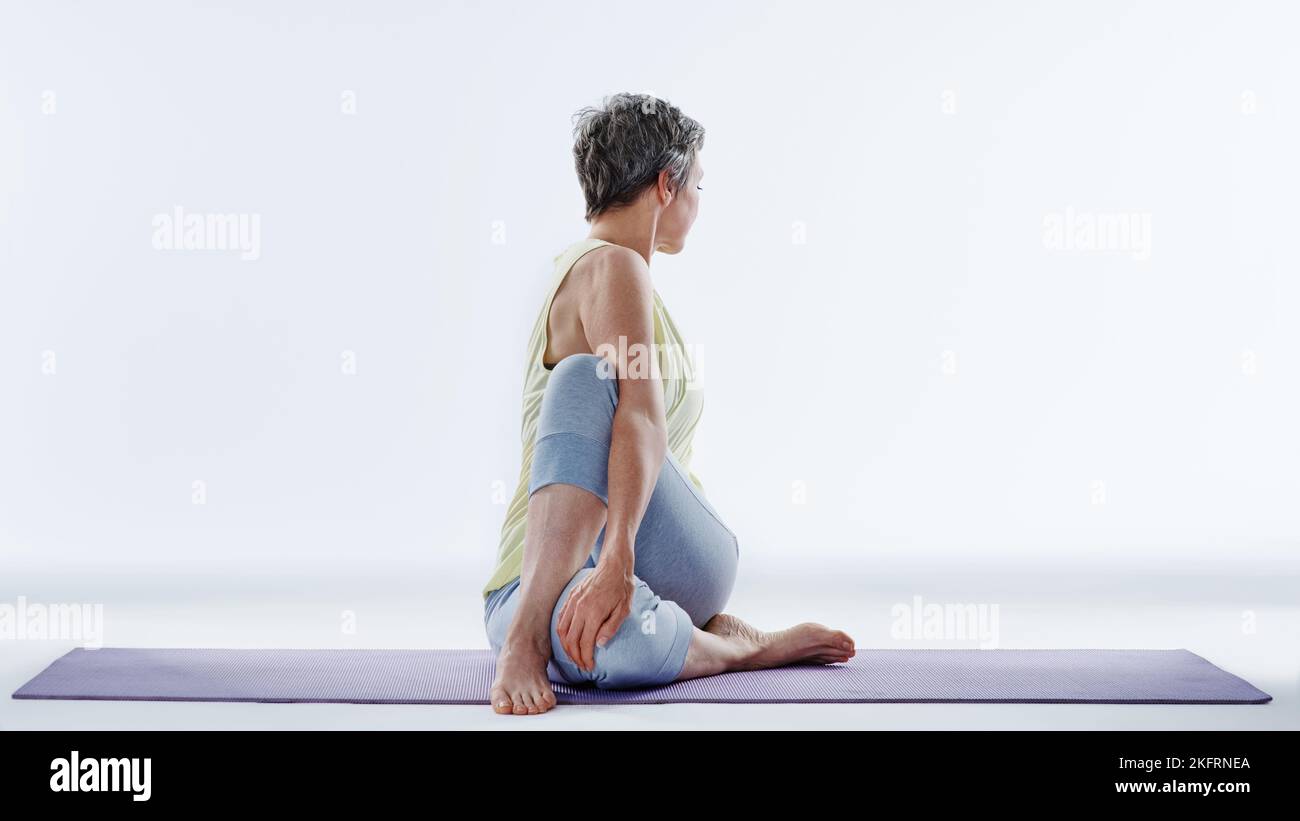 Fare alcune stirate di yoga. Scatto completo di una donna che si allunga prima dello yoga. Foto Stock