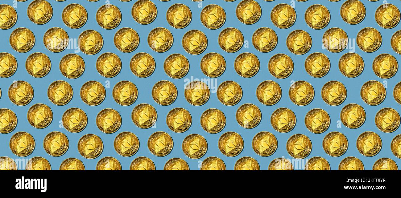 Molte monete d'oro con il simbolo della criptovaluta Ethereum che forma un motivo senza cuciture su sfondo blu Foto Stock