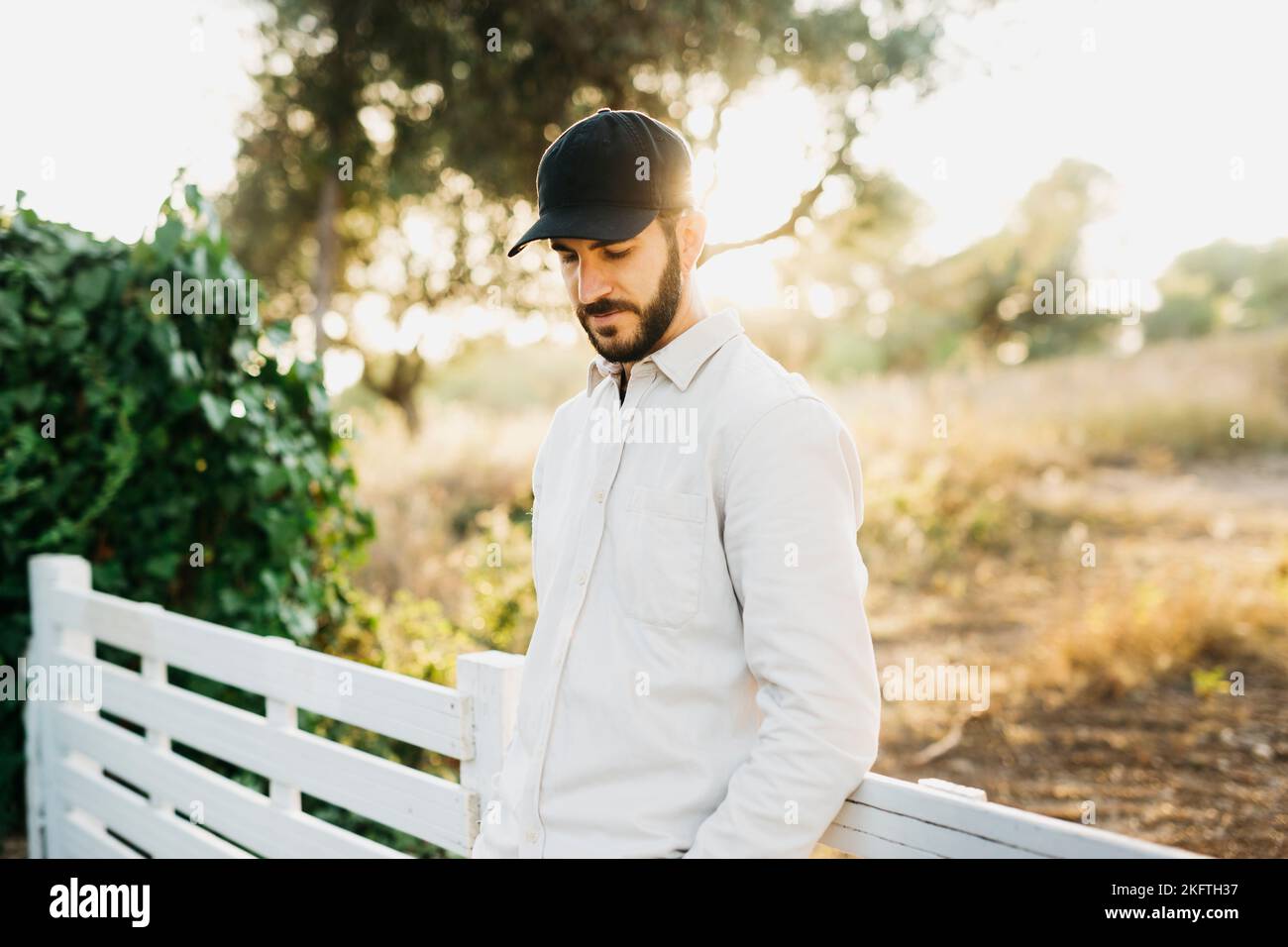 Ritratto di un giovane uomo bearato che indossa un berretto nero in campagna Foto Stock
