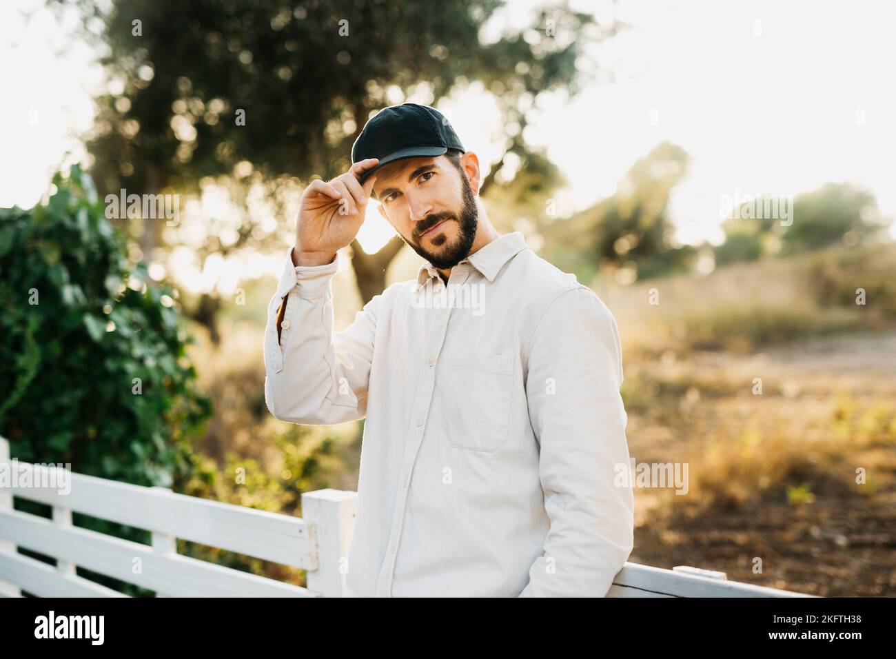 Ritratto di un giovane uomo bearato che indossa un berretto nero in campagna Foto Stock