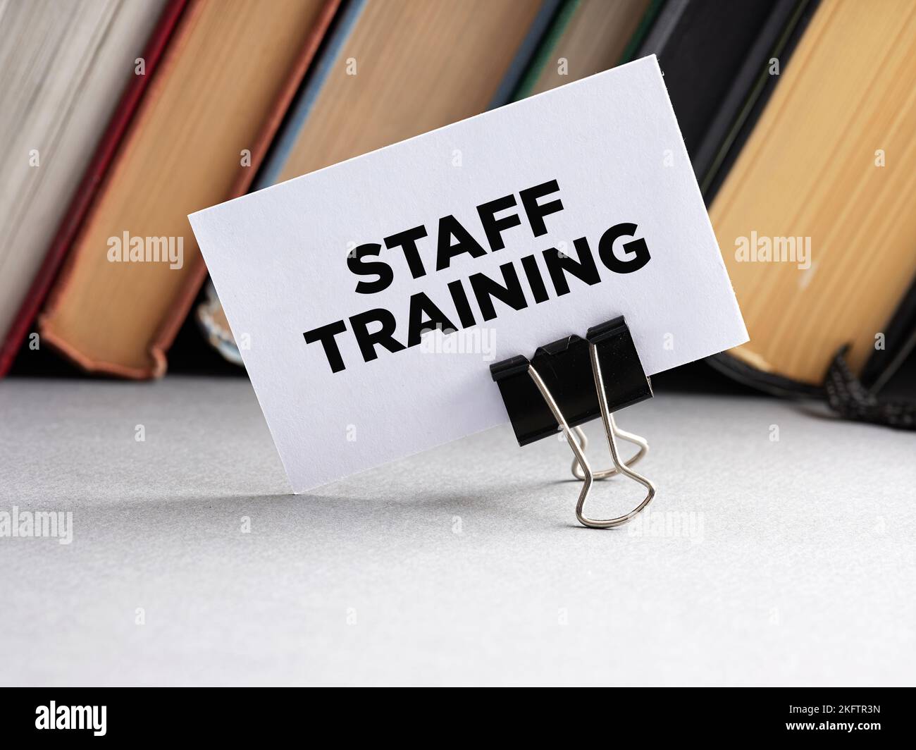 La formazione del personale di parola scritta su un biglietto da visita con lo sfondo dei libri. Concetto aziendale per la formazione, l'istruzione e il miglioramento dei dipendenti. Foto Stock