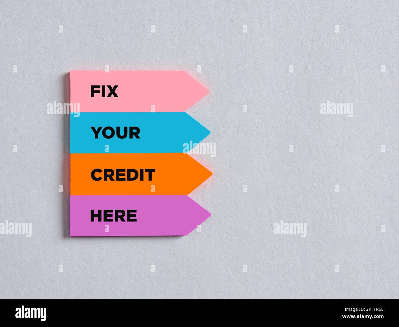 Adesivi colorati a forma di freccia con il messaggio risolvere il tuo credito qui. Concetto finanziario di affari di prestito. Foto Stock