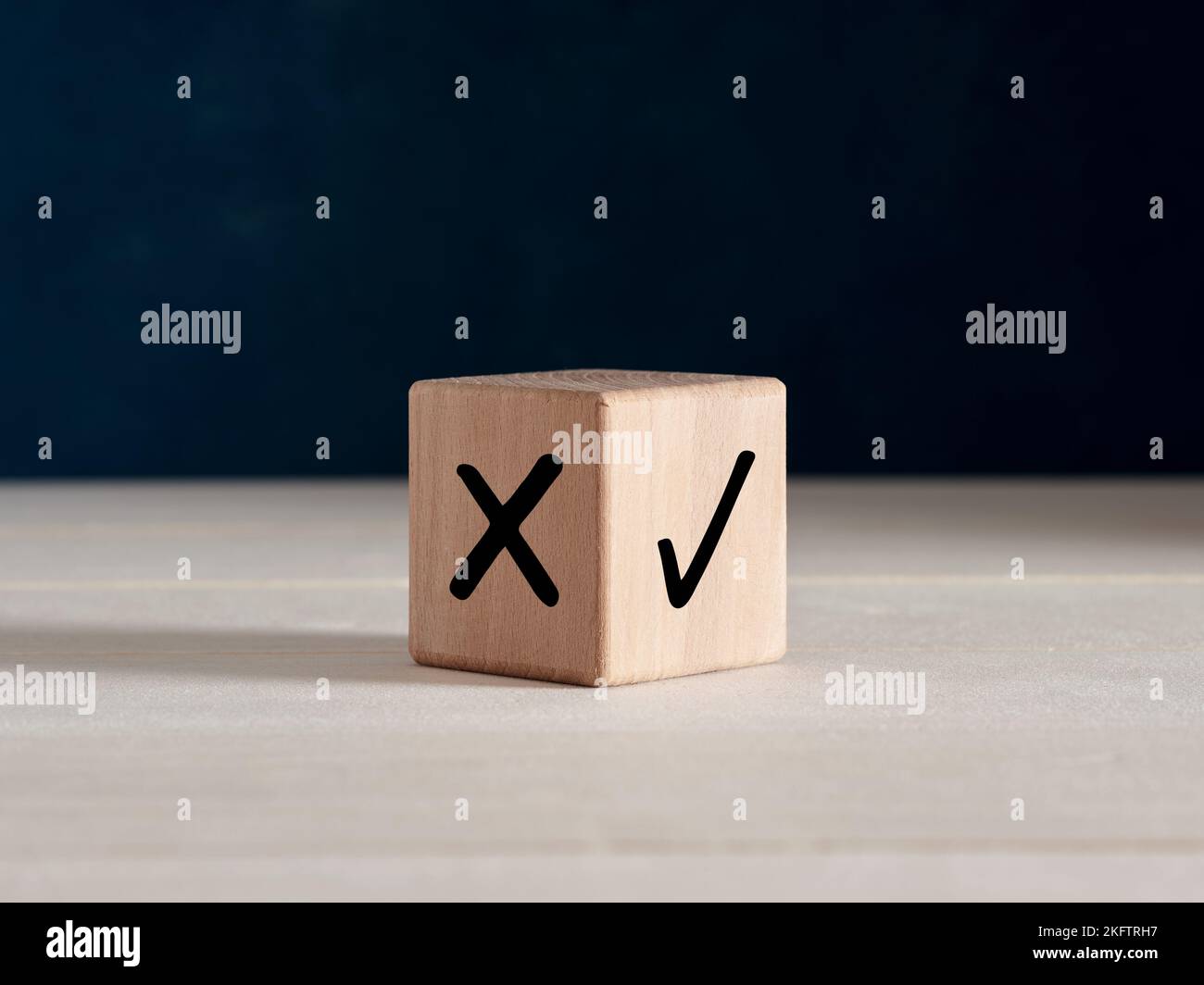 Prendere la decisione giusta, votare sì o no o scegliere il concetto di opzione corretto. Simboli di segno di spunta e croce corretti sul cubo di legno. Foto Stock