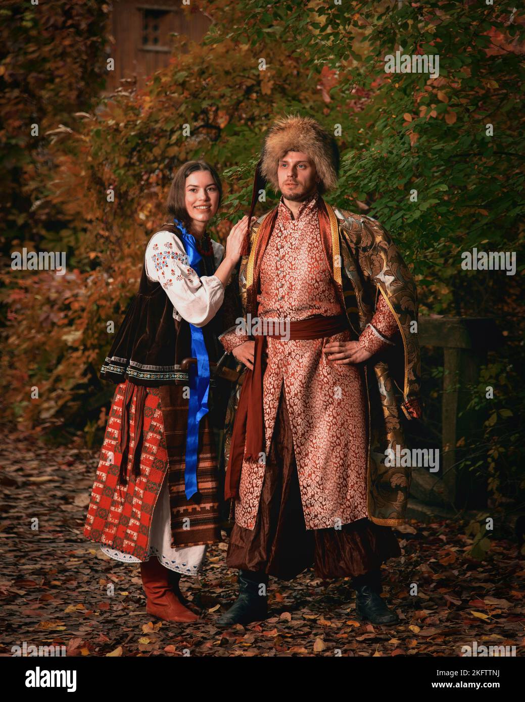 Giovane coppia sorridente vestita tradizionale ucraino abbigliamento. Uomo e donna Cossack in costumi ricamati all'aperto. Vestito vintage Foto Stock