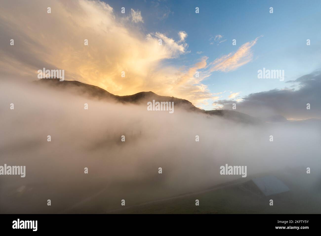 Le nuvole di nebbia si sgombrano sotto un cielo sgonfio dopo una tempesta estiva di fulmini sull'Ackernalm, Tirolo, Austria Foto Stock