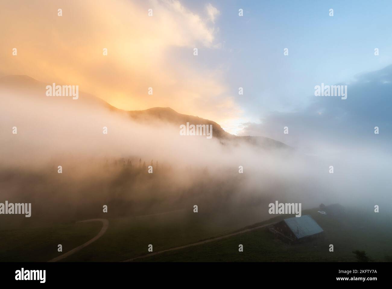 Le nuvole di nebbia si sgombrano sotto un cielo sgonfio dopo una tempesta estiva di fulmini sull'Ackernalm, Tirolo, Austria Foto Stock