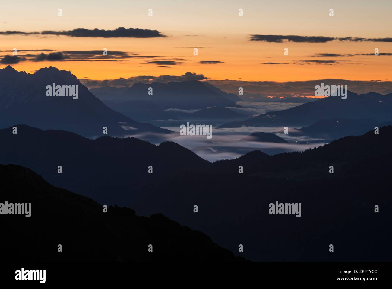 Vista dal Monte Veitsberg sull'alba sulle montagne Kaiser e sulle Alpi di Kitzbühel, Tirolo, Austria Foto Stock