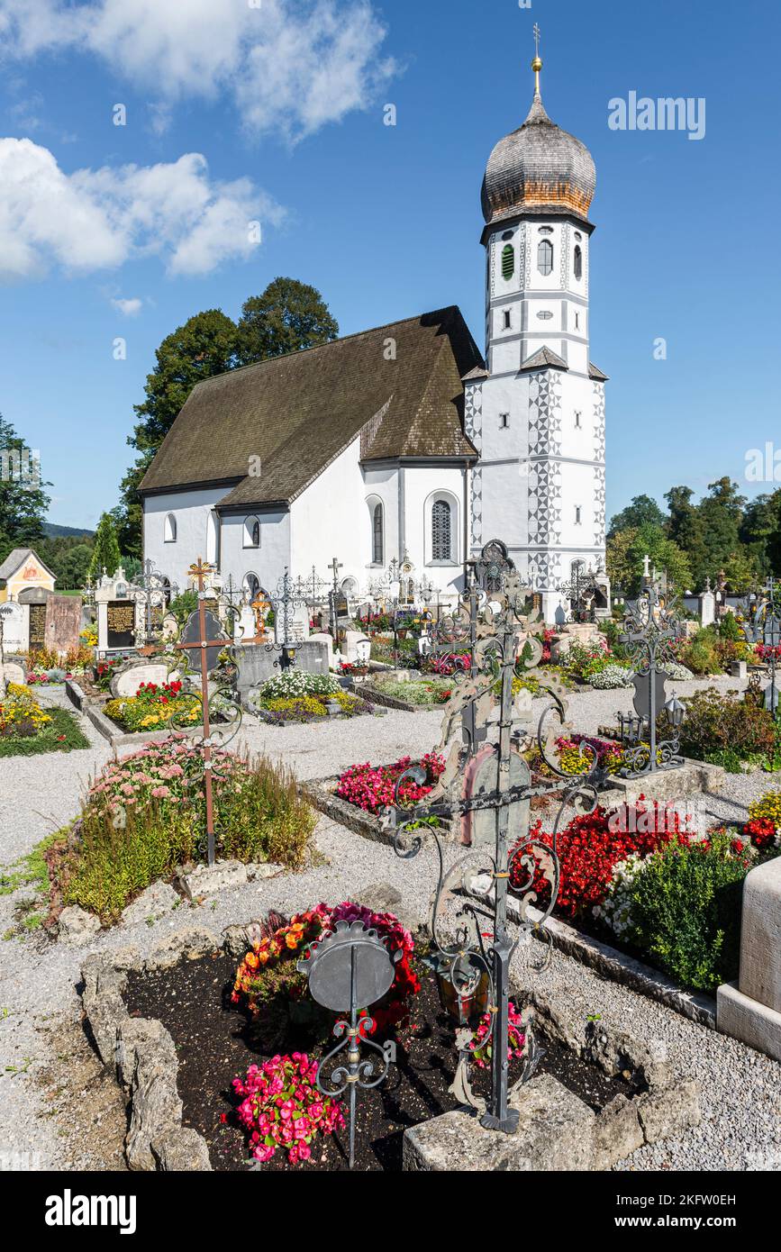 La chiesa cattolica barocca della protezione della Vergine Maria circondata da tombe del cimitero Fischbachau, Baviera, Germania Foto Stock