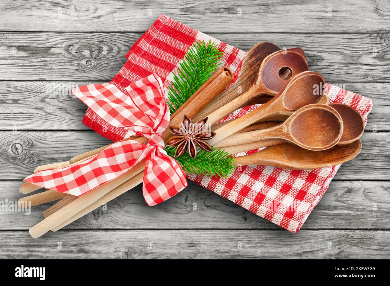 Natale e cucchiai da cucina in legno con cannella, rami di abete, anice e asciugamano rosso Foto Stock