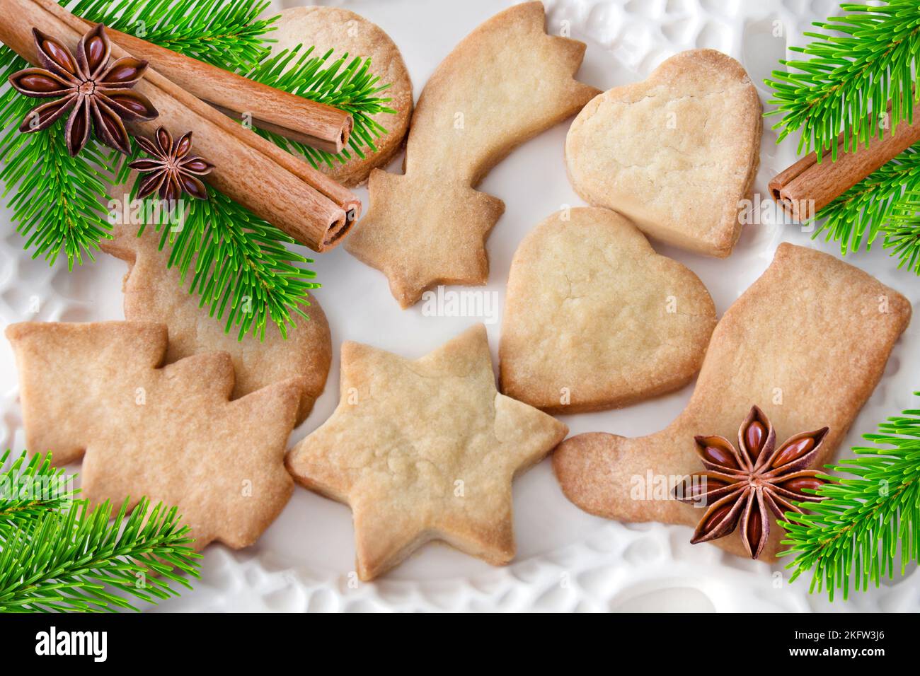Biscotti di Natale con cannella, rami di abete e anice su piatto bianco Foto Stock