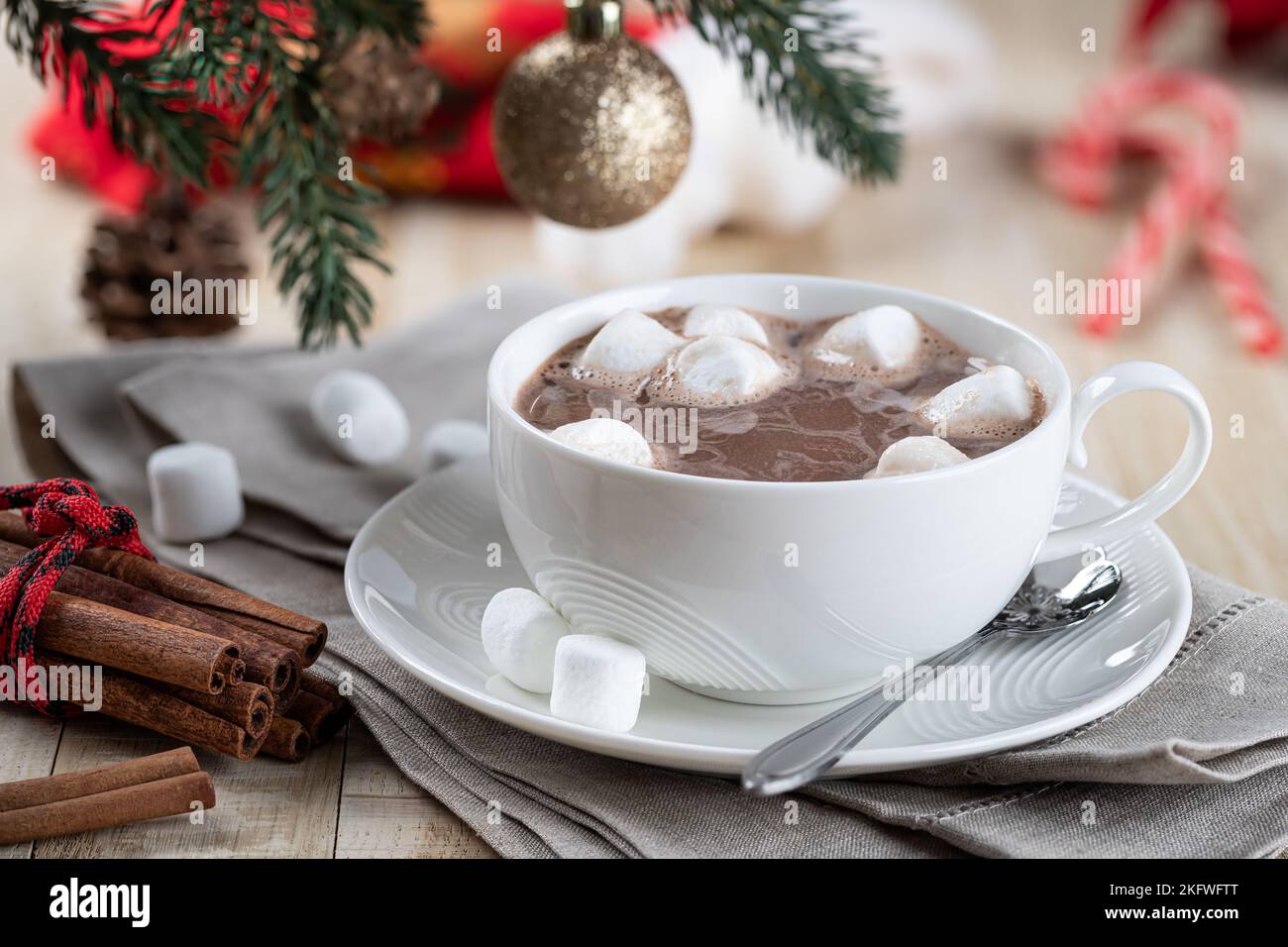 Tazza di cioccolata calda e marshmallows su un tavolo di legno con decorazioni natalizie sullo sfondo Foto Stock