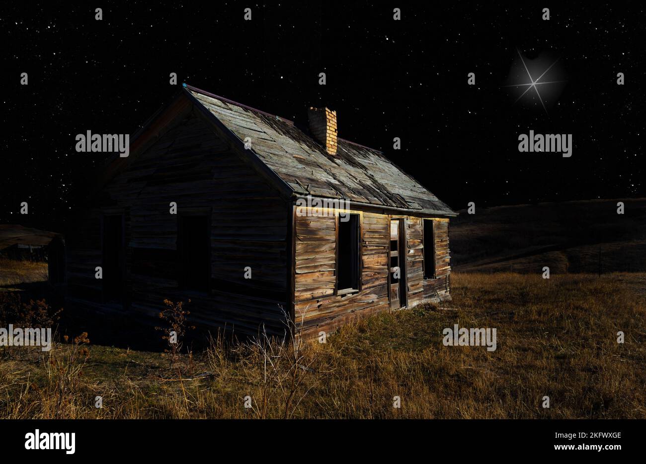 Casa deserta in rovina con la stella di Natale che splende brillantemente sopra Foto Stock