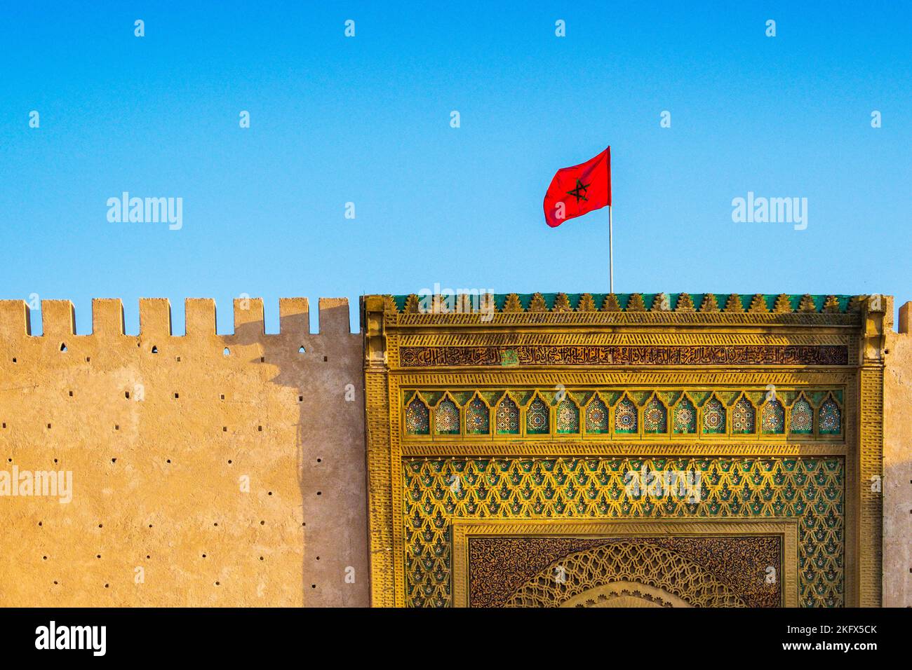 La bandiera marocchina sorvola le antiche mura della medina di Meknes, Marocco Foto Stock